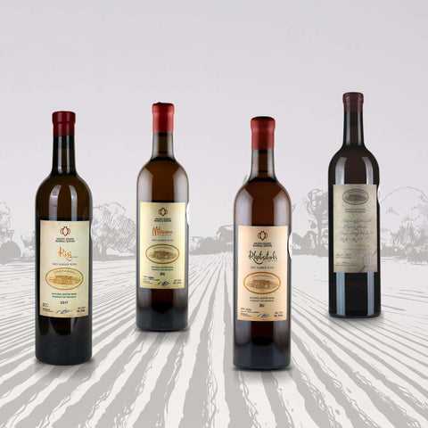 Georgian Amber Qvevri Wine Set displaying four bottles on a rustic backdrop, featuring Kisi and other celebrated grape varieties.